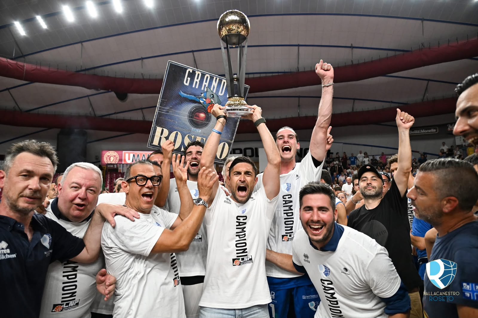 Squadra e staff della Pallacanestro Roseto esultano sul campo alzando la coppa del campionato