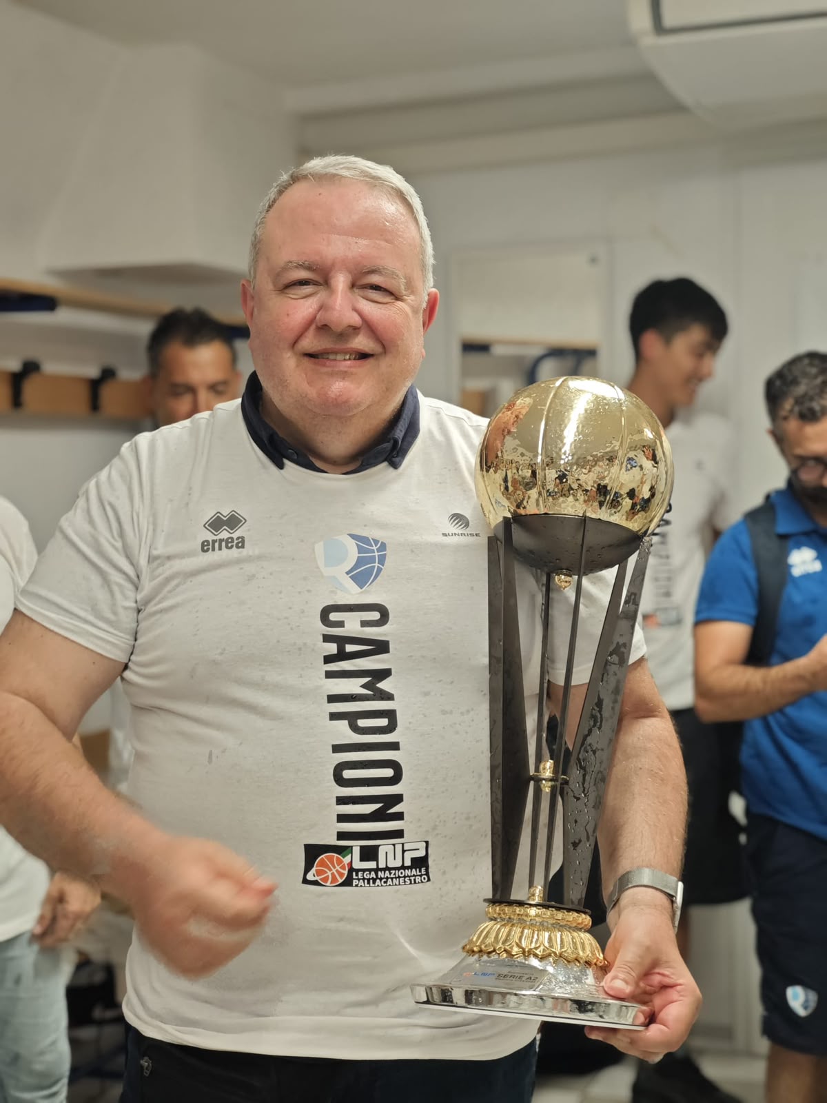 Luigi Lamona sorride negli spogliatoi con in mano il trofeo dorato del campionato